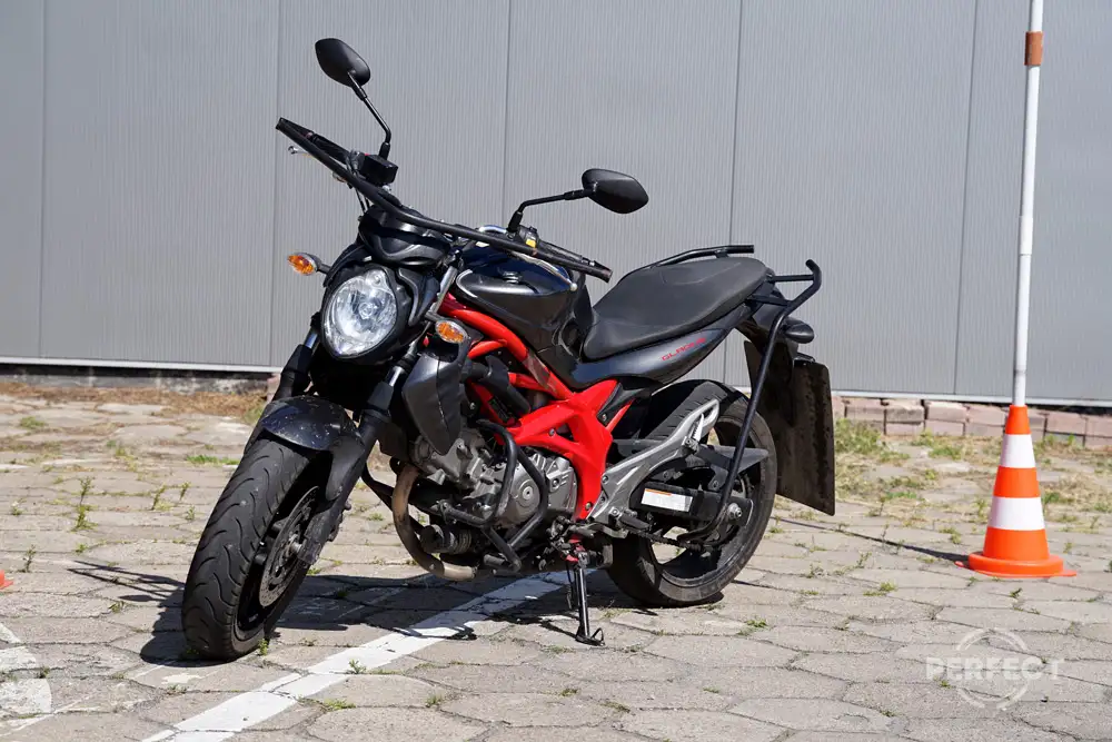 Motocykl Suzuki Gladius na placu manewrowym Perfect Zamość. Pojazd jest wykorzystywany do egzaminów na prawo jazdy kategorii A. Motocykl ma pojemność 645 cm³ i moc 53 kW (72 KM).
