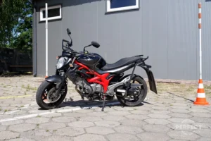 Motocykl Suzuki Gladius na placu manewrowym Perfect Zamość. Pojazd jest wykorzystywany do egzaminów na prawo jazdy kategorii A. Motocykl ma pojemność 645 cm³ i moc 53 kW (72 KM).