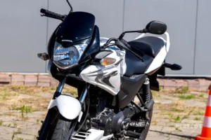Czarny motocykl Honda CB125R na placu egzaminacyjnym WORD Zamość. Pojazd egzaminacyjny kategorii A1 z mocą 15 KM i silnikiem 125 cm³. Na zdjęciu widoczny bok i przód motocykla z charakterystycznym okrągłym reflektorem LED w stylu Neo Sports Café.